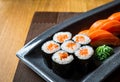 Close up Sushi Rolls Set with wasabi,  on a Black plate on wooden table in the restaurant. Royalty Free Stock Photo