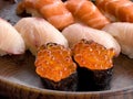 Close up of sushi salmon fish eggs with yellow tail and salmon pieces in background Royalty Free Stock Photo