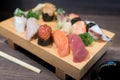 Close-up sushi and sashimi mixed on wooden plate on black wooden Royalty Free Stock Photo