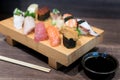 Close-up sushi and sashimi mixed on wooden plate on black wooden Royalty Free Stock Photo