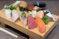 Close-up sushi and sashimi mixed on wooden plate on black wooden Royalty Free Stock Photo