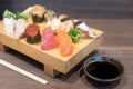 Close-up sushi and sashimi mixed on wooden plate on black wooden Royalty Free Stock Photo