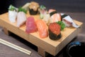 Close-up sushi and sashimi mixed on wooden plate on black wooden Royalty Free Stock Photo