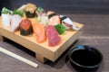 Close-up sushi and sashimi mixed on wooden plate on black wooden Royalty Free Stock Photo