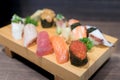 Close-up sushi and sashimi mixed on wooden plate on black wooden Royalty Free Stock Photo