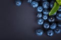 Close-up of sweet blueberries with mint. Blueberries on a dark background. Fresh, healthful and tasty berries.