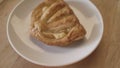 Close up of sweet bun lying on the white glass plate and rotating. Stock footage. Top view of spinning pastry good