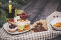 Close-up of sweets on a white plate: coconut biscuit, pastila, meringue, cream roses, Turkish delight, next to a broken chocolate