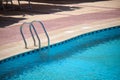 Close up of swimming pool stainless steel handrail descending into tortoise clear pool water. Accessibility of Royalty Free Stock Photo