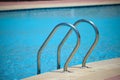 Close up of swimming pool stainless steel handrail descending into tortoise clear pool water. Accessibility of Royalty Free Stock Photo