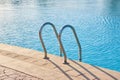 Close up of swimming pool stainless steel handrail descending into tortoise clear pool water. Accessibility of Royalty Free Stock Photo