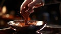 A close-up of a Swiss chocolatier's hand tempering a bowl of molten chocolate, capturing the glossy, velvety texture