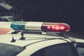 Close up of a swithched rotating beacon of a police car. The top of the police patrol car with flasher and antennas. A patrol car