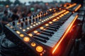 Close-up of synthesizer with orange lights and keys in blurred concert crowd background
