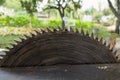 Close up of table circular saw blade in the garden with trees in background. Woodwork, Work hazards at home. Detail view