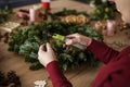 Table full of decorations and making Christmas wreaths