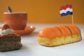 Cup of coffee, orange cake and eclair. Traditional treat for Dutch event Kings Day, Koningsdag Royalty Free Stock Photo