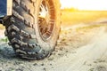 Close-up tail view of ATV quad bike on dirt country road at evening sunset time. Dirty wheel of AWD all-terrain vehicle. Travel Royalty Free Stock Photo