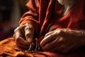 close-up of a tailors hands threading a needle