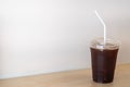 Close up of take away plastic cup of iced black coffee Americano on wooden table in restaurant Royalty Free Stock Photo