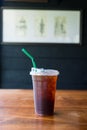 Close up of take away plastic cup of iced black coffee on wooden table Royalty Free Stock Photo
