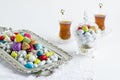 Colorful almond candies in crystal bowl on white with Turkish Tea and vintage candy tray Royalty Free Stock Photo