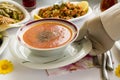 Gloved hand serving Traditional Turkish Soup on the Ramadan Dinner Table.