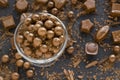 Milk chocolate covered hazelnuts with grated chocolate chips in an elegant bowl, with shaped chocolates