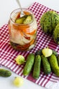 Mixed pickle jar with unripe,pickled vegetables on white background