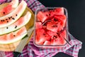 Sliced watermelon in glass container with black seeds on black background Royalty Free Stock Photo