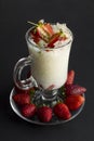 Traditional Turkish Ramadan Dessert;Gullac with strawberries in Latte Coffee Cup on black background.