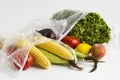 Uncooked,fresh vegetables and fruits in plastic shopping bags on white background with copy space. Royalty Free Stock Photo