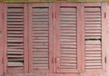 Old rose color wooden window with louver panel that peeling and damaged