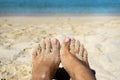 Close up tan barefoot with a little sand on beach background Royalty Free Stock Photo