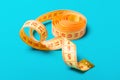 Close up of tangled measuring tape on blue background. Fitness and healthy diet concep with perspective view