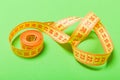 Close up of tangled measuring tape on green background. Fitness and healthy diet concep with perspective view