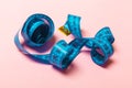 Close up of tangled measuring tape on pink background. Fitness and healthy diet concep with perspective view