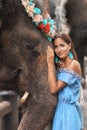 Close-up of tanned woman and big elephant together