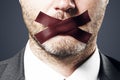 Close up of taped caucasian businessman mouth.