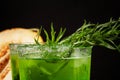 Close-up of a tarragon drink. A glass of green alcoholic lime cocktail. Cold herbal drink and sweet melon on a black background. Royalty Free Stock Photo