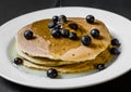 Close up of a tasty american pancake with blueberries and maple syrup