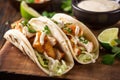 Close-up of Tasty and Authentic Fish Tacos with Creamy Sauce and Lime Wedges Royalty Free Stock Photo