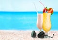 Close-up of tasty drinks on sandy background with