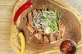 Close up on tasty Grilled Pork neck served on pita bread with onion, microgreen and hot pepper. Wooden background. Copy space. Royalty Free Stock Photo