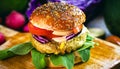 Close-up of tasty, home-made vegan hamburger on wooden table with fresh vegetables around Royalty Free Stock Photo