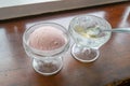 The tasty homemade cool strawberry ice cream scoop in glass cup on wood table