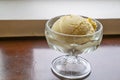 The tasty homemade cool vanilla ice cream scoop in glass cup on wood table. Royalty Free Stock Photo
