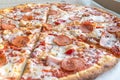 Close Up of Tasty Hot Pizza with Bacon, pepperoni sausage, ham, mozzarella cheese, sweet pepper, herbs, red onion. Food to order Royalty Free Stock Photo