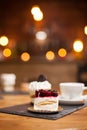 Close up of tasty mini cake with fruits on top over a wooden table in a coffee shop Royalty Free Stock Photo