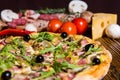 Close up of tasty pizza with arugula and olives, tomatoes and cu Royalty Free Stock Photo